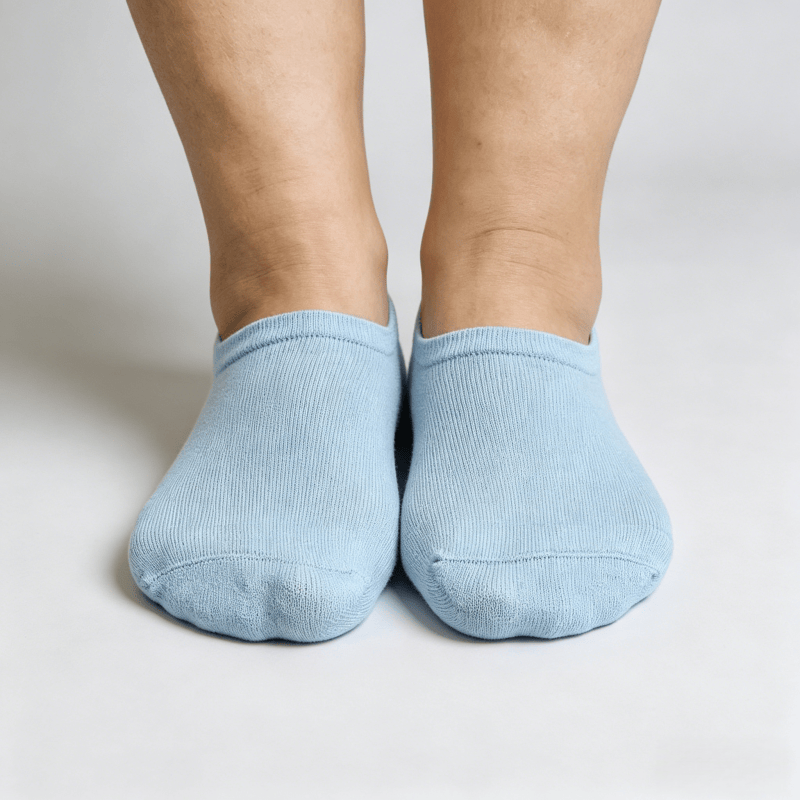 Light blue diabetic no-show socks with silicone heel grip strip and non-restrictive fit to prevent shifting while walking